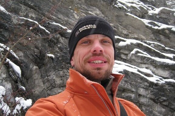 Geocacher ATIP během zimního lovu keší v zasněženém skalním terénu.