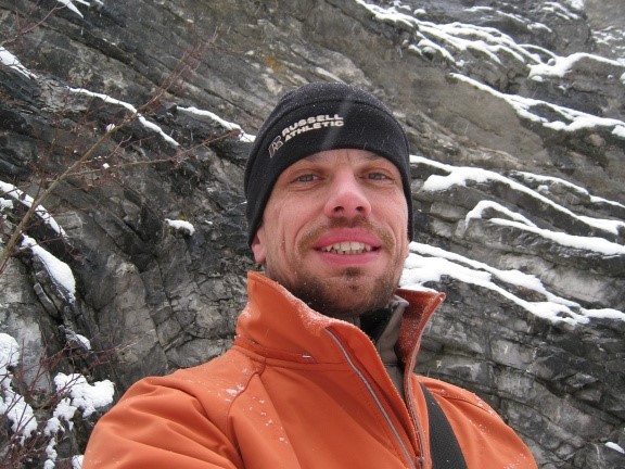 Geocacher ATIP během zimního lovu keší v zasněženém skalním terénu.