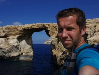 Bohemian Reviewer při geocachingu u skalního oblouku nad mořem