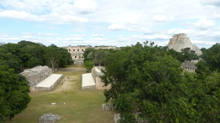 Celkový pohled na archeologické naleziště Uxmal s Nunnery Quadrangle a Pyramidou kouzelníka obklopené zelení.