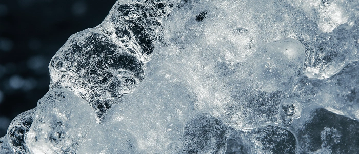 Detail ledu zobrazující strukturu mrazu – symbol odolných materiálů pro zimní geocachingové keše.