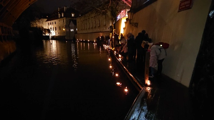 Geocacheři vypouštějí svíčkami osvětlené lodičky na hladinu Čertovky při tradičním megaeventu Adventní geoskořápky v Praze.