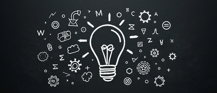 Kreslená žárovka na tabuli obklopená symboly a vzorci představuje logické myšlení a plánování trasy při geocachingu.