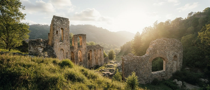 Sluncem prozářené zříceniny uprostřed zeleného údolí, historické kamenné zdi obklopené přírodou a klidnou atmosférou - ideální místo pro geokeš.